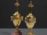 paire de vases anciens en laiton, ornés de motifs bleus et dorés, posés sur des socles en marbre