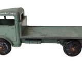 un camion jouet posé sur une surface blanche