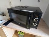 un micro-ondes posé sur une étagère dans la cuisine