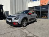 une voiture argentée garée devant un bâtiment dans un parking