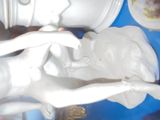 a statue of a woman sitting on a man ' s lap
