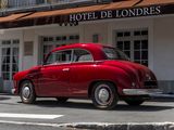 a red car that is parked in front of a hotel