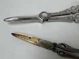 two pairs of scissors sitting on a table next to each other