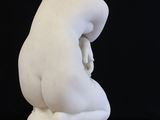 marble statue of a boy kneeling on a marble base