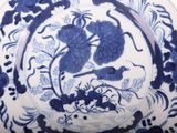 a blue and white plate with a bird and flowers on it