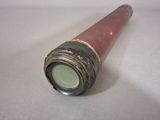 a small red pipe with a green top on a white surface