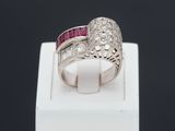 a close up of a diamond and ruby ring on a white box