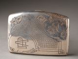 an antique silver cigarette case with a design on the front