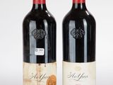 deux bouteilles de vin rouge posées l'une à côté de l'autre sur une surface blanche
