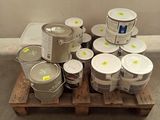 many cans of paint on a pallet in a room