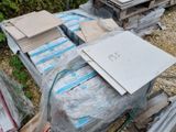 une pile de cartons et un ordinateur portable posé par terre