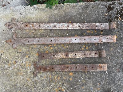 quatre vieux outils en fer rouillés posés par terre