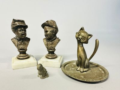 three figurines of a cat and a dog on a plate