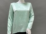 the mannequin is wearing a green top and black leggings
