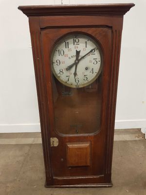 une vieille horloge de parquet en bois posée à même le sol dans une pièce