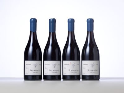 trois bouteilles de vin rouge sont alignées sur une table