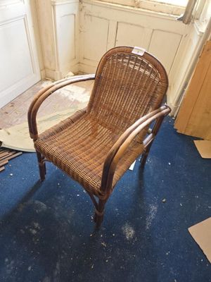 une chaise en osier dans un coin de la pièce
