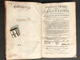 an open book with a pair of silver cufflinks on top of it