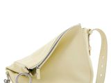 un sac à main blanc muni d'une fermeture éclair sur le côté et d'un anneau métallique