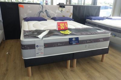 un lit sur lequel sont posés de nombreux matelas
