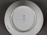 a white plate with a flower on it on a table