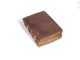 an old book that is sitting on a white surface