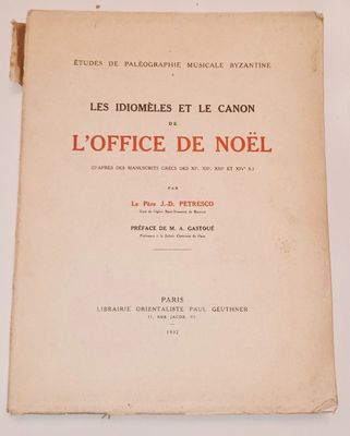 un vieux livre posé sur une table à côté d'un mur blanc