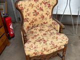 une chaise dont l'assise est recouverte d'un tissu à motifs floraux, dans un garage
