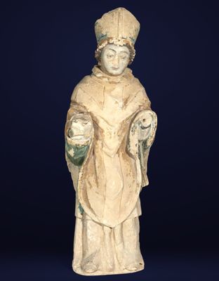 an old statue of a man with a hat and a robe