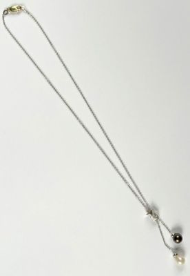 silver necklace with black and white pearls on a white background