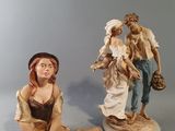 deux figurines représentant un homme et une femme assis par terre