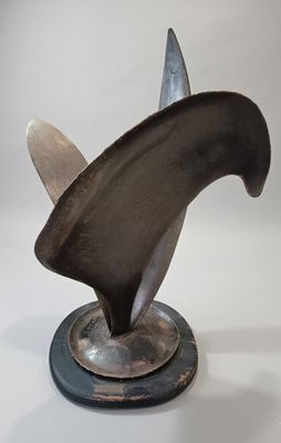 une sculpture métallique représentant un aileron de requin, posée sur un socle