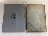 an old book sitting on top of a table next to a closed book