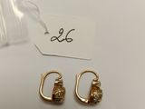 a pair of gold earrings on a white surface