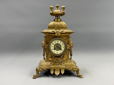 a gold clock with a bird on top of it