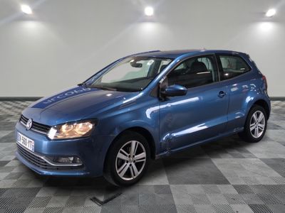 the blue volkswagen polo is parked on a checkered tile floor
