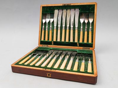 une boîte en bois contenant un ensemble de couteaux et de fourchettes