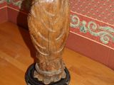 a wooden statue on a wooden floor in a room
