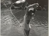 photographie en noir et blanc d'une femme en maillot de bain tenant un frisbee