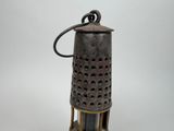 a small metal lantern with a handle on a table
