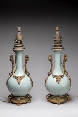 paire de vases bleus et dorés munis d'anses et posés sur des socles