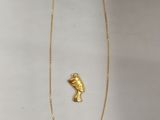 Gros plan sur un collier en or orné d'un oiseau