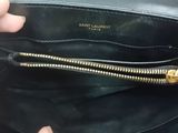 someone is holding a black purse with a gold chain around it