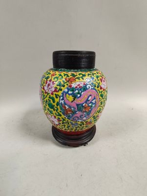 a colorful vase with a black lid sitting on a table