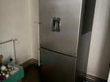 a silver refrigerator in the corner of a room