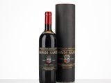 une bouteille de vin rouge à côté d'une boîte noire