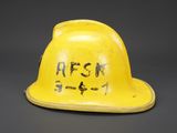 an old yellow helmet with writing on it sitting on a table