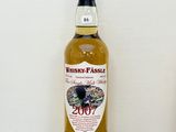 une bouteille de whisky posée sur une table à côté d'une bouteille de vin