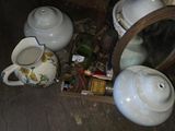 une théière et une autre théière posées par terre à côté d'un miroir