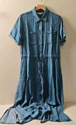 une robe en jean suspendue à un cintre à côté d'une pile de vêtements